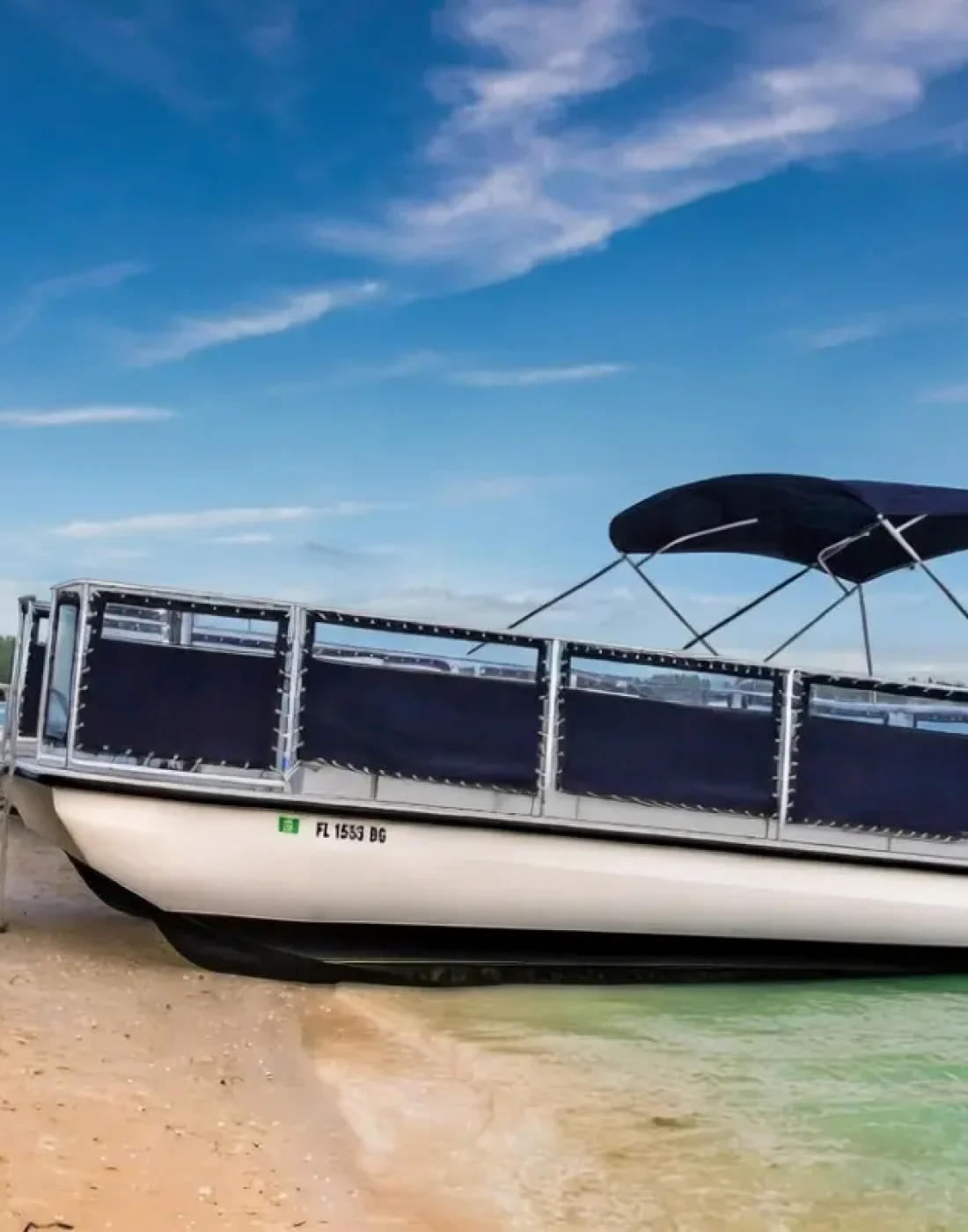 Beachcat 26x10 commercial pontoon boat beached with reinforced hull and Bimini top